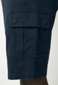 Marineblaue Cargo-Shorts aus Baumwolle, mit einer seitlichen Tasche mit Klappe, genähten Nähten und geradem Beinschnitt.