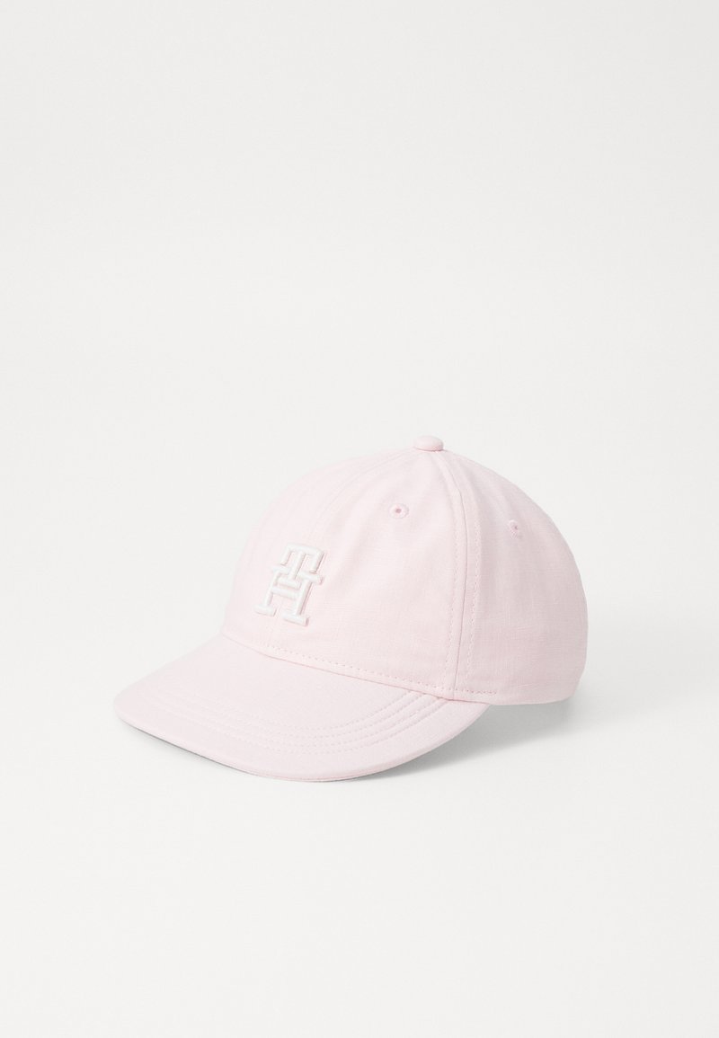 Rosa bomull baseball cap med böjd skärm och broderad vit logotyp på framsidan. Har ventilationshål med ögon och justerbart rem.