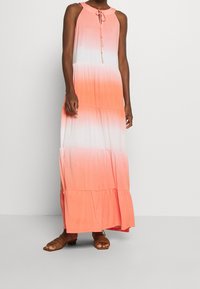 Vestido maxi con un diseño de ombré graduado de blanco a coral. Está hecho de un material suave y cuenta con un lazo en el escote y una falda en capas.