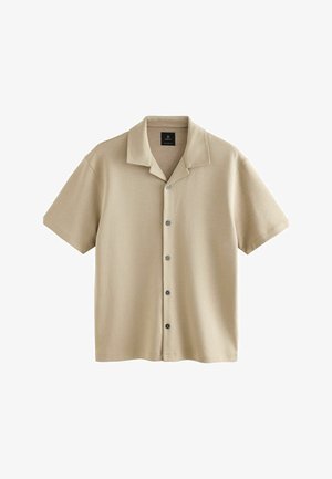 Camicia beige a maniche corte realizzata in tessuto morbido, con chiusura frontale con bottoni, colletto classico e trama sottile.
