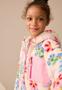 Felpa in fleece con un design floreale colorato in rosa, blu e verde. Include una tasca frontale rosa e un tessuto morbido e testurizzato.