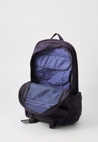 Mochila roxa escura com abertura com fecho, apresentando um interior azul, painel traseiro acolchoado e detalhe de bolso em rede no interior.