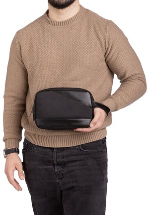 Beauty case nero con pannello superiore testurizzato e pannello inferiore liscio, chiusura con zip e un cinturino per il polso per un facile trasporto.