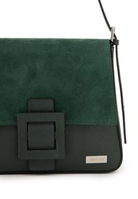 Grüne Wildleder- und strukturiertes Lederhandtasche mit einem umklappbaren Deckel, quadratischem Akzentverschluss und silberner Logo-Plakette. Verstellbarer Schulterriemen angebracht.
