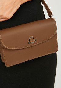 Borsa a tracolla in ecopelle marrone con patta, caratterizzata da un accento in metallo dorato con il logo e cuciture in contrasto lungo i bordi.