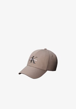 Beżowa czapka baseballowa Calvin Klein z zakrzywionym daszkiem i wyhaftowanym czarno-białym logo CK na przednim panelu.