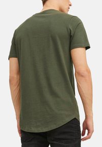 T-shirt verde oliva a maniche corte, realizzato in un tessuto morbido, con orlo arrotondato e un design semplice senza grafiche o decorazioni.