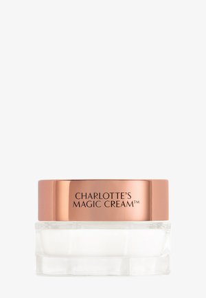 Clear glass jar with rose gold lid labeled "Charlotte's Magic Cream" containing white cosmetic cream inside.