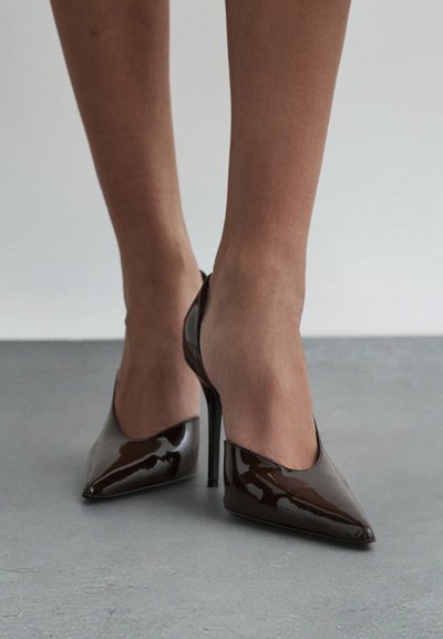 Smeđe salonke od lakirane kože s špicastim vrhom i otvorenom petom, s profinjenim siluetom i stileto petom.
