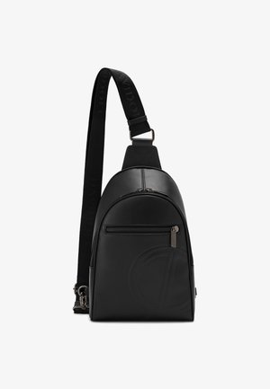 Black leather sling bag with a curved shape, featuring a front zip pocket, embossed logo, and a textured shoulder strap.