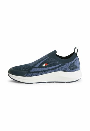 Zapatilla deportiva sin cordones de punto en azul marino y morado con suela blanca, puntera negra, lazo en el talón y logotipo de Tommy Hilfiger en el lateral.
