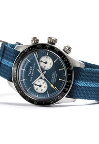 Timex Waterbury hronogrāfs pulkstenis ar zilu ciparnīcu, sudraba apakšciparnīcām, melnu taksimetra rāmīti un strukturētu zilu auduma siksniņu.