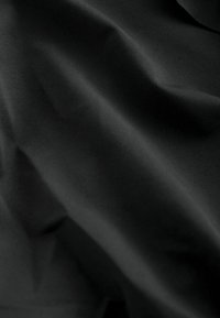 Black fabric with a smooth texture, showing subtle folds and a soft sheen. Material appears lightweight and non-transparent.