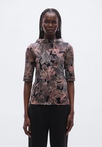 Floral patterned top with black background, featuring short sleeves and a high collar. Made of smooth fabric with a detailed flower design in pink and white.