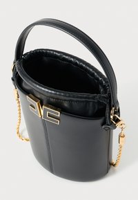 Μαύρη δερμάτινη τσάντα τύπου κουβά με σφικτό πάνω μέρος, χρυσή αλυσίδα για ιμάντα και μεγάλο χρυσό κούμπωμα μπροστά. Ομαλή υφή και κομψό σχήμα.