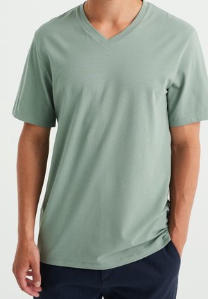 T-shirt vert clair à manches courtes et décolleté en V, fabriqué en tissu doux. Il présente une coupe décontractée et une texture lisse. Convient pour une tenue décontractée.