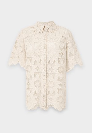 Bluse i kremfarge i blonde, med blomsterbroderte mønstre, krage, korte ermer og bølget kantdetalj. Knappelukking foran.