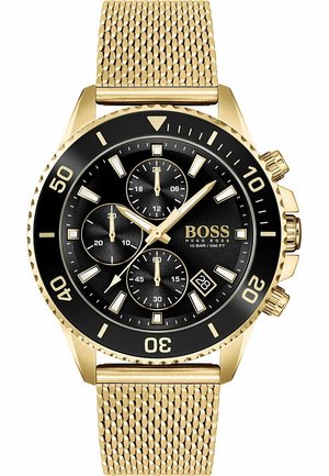 Guldfarvet armbåndsur med sort urskive, tre underskiver, datovindue kl. 4 og guld mesh-rem, mærket Hugo Boss og vandtæt op til 10 bar.
