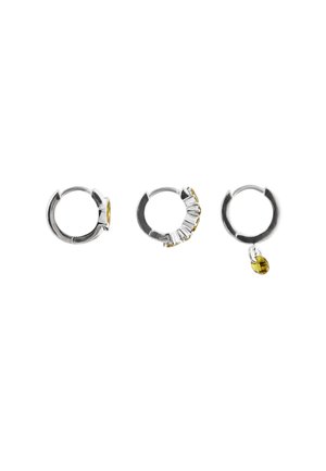 Three silver hoop earrings, one with a small yellow stone, one with multiple clear gemstones, and one with a dangling yellow charm.