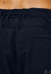 Czarne szorty wykonane z lekkiego, strukturalnego materiału. Posiadają elastyczny pas oraz małą kieszonkę. Widoczny delikatny wzór kratki.