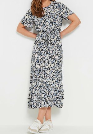 Sukienka w granatowym kolorze w kwiatowy wzór, z krótkimi rękawami, taliowana i z falbaną na dole. Do tego białe trampki z beżowymi akcentami.