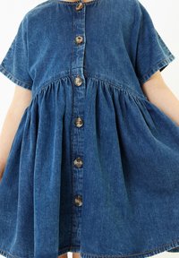 Robe en denim avec un col rond, des manches courtes et une fermeture à boutons sur le devant. Taille froncée avec une jupe évasée. Couleur bleue.