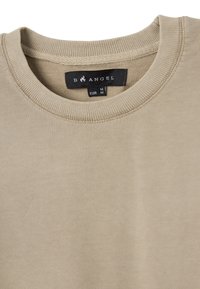 Felpa beige con scollo rotondo e rifiniture a coste. Presenta un'etichetta con la scritta "B ANGEL" e taglia "M". Texture liscia senza motivi.