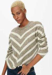 Pull en gris clair avec des rayures en chevrons crème, offrant un col rond et des manches longues. Fabriqué en un matériau tricoté doux et texturé.