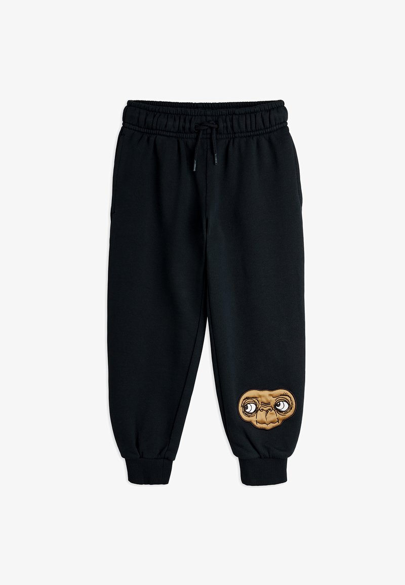 Czarne dresowe spodnie z elastycznym pasem, regulowanym sznurkiem i ściągaczami na nogawkach. Na prawym udzie znajduje się haft postaci.