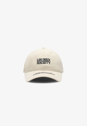 Cappello in cotone beige con visiera curva. Presenta la scritta "LES DEUX" e "SOCIETY" ricamata in nero. Include dettagli di branding sulla parte inferiore della visiera.