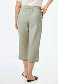 Hellgrüne, leinenartige cropped Hose mit einem elastischen Bund und zwei Gesäßtaschen, die eine glatte, strukturierte Oberfläche aufweist.