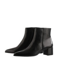 Une paire de bottines en cuir noir élégantes avec une fermeture éclair sur le côté, un bout pointu et des talons carrés sur un fond blanc.