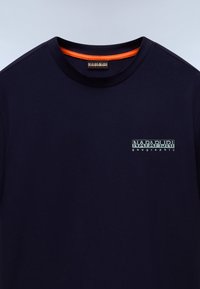 Marineblå bomulds T-shirt med rund hals, med en orange detalje indeni kraven og et lille trykt logo på brystet.