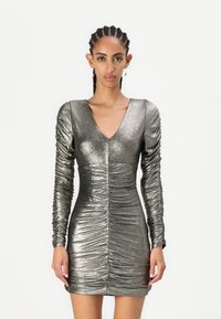 Robe grise métallique avec de longues manches froncées, décolleté en V profond et silhouette ajustée. Tissu texturé avec des détails plissés sur toute la surface.