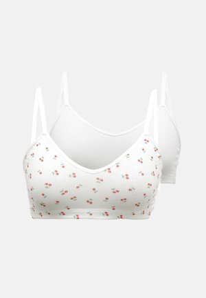 White bralette set featuring a ribbed texture and a floral pattern of small red cherries and green leaves, with adjustable straps.