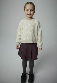 Maglione azzurro beige lavorato a maglia con lettere bianche; gonna plissettata di prugna scura; collant grigi a costine; scarpe nere con lacci. Outfit semplice e casual.