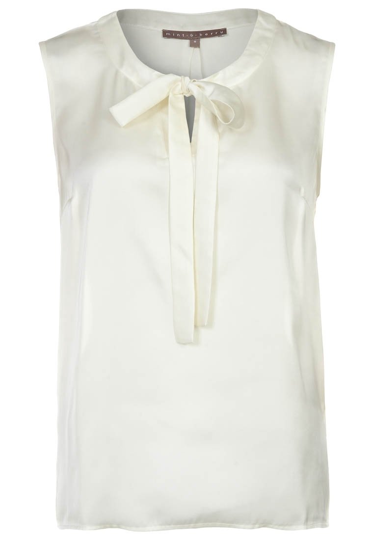 Bezrukává krémová blůza z hladkého materiálu, s kulatým výstřihem a mašlí vpředu. Bez viditelných vzorů nebo akcentů.