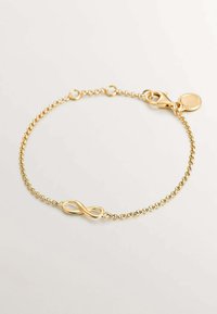 Pulsera chapada en oro con un centro en forma de símbolo de infinito. Presenta una delicada cadena y cierre, mostrando una textura suave y un diseño minimalista.