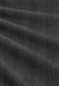 Dunkelgrauer Stoff mit dezentem Fischgrätmuster und schwachen vertikalen gelben Nadelstreifen, gezeigt in sanften Falten.