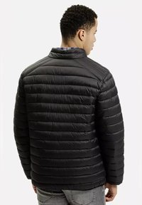 Czarna kurtka puchowa o pikowanym wzorze, z wysokim kołnierzem i gładką teksturą. Widok z tyłu pokazuje poziome szwy i dopasowaną sylwetkę.