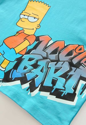 Tegen een teal kleurige katoenen t-shirt met een afbeelding van een cartoonfiguur in een oranje shirt en blauwe shorts, met de tekst "100% BART" in vetgedrukte, gestileerde letters.