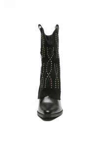 Botín negro hasta el tobillo con punta afilada, con parte superior de ante y tachuelas metálicas decorativas en un patrón curvado a los lados. Tacón de cuero suave.