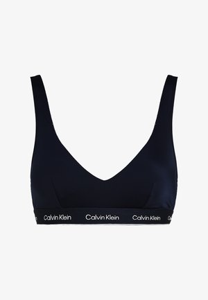 Marineblaue Calvin Klein Bralette. Glattes Material mit tiefem V-Ausschnitt, breiten Trägern und einem elastischen Band mit Markenlogo am unteren Rand. Nahtloses Design.