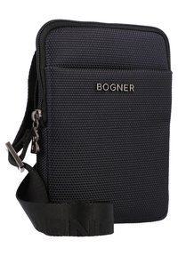 Black textured fabric crossbody bag with a rectangular shape, zip closure, adjustable strap, and metallic logo detailing.