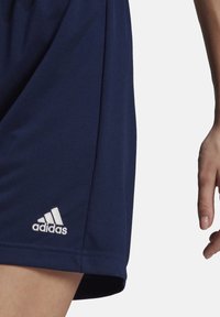 Marinefarbene Sportshorts aus glattem Stoff, mit einem leicht lockeren Schnitt und einem gestickten weißen Adidas-Logo am unteren Saum.