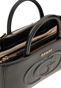 Borsa a mano in pelle nera con logo testurizzato, hardware dorato, manici doppi e un compartimento con zip foderato in beige.