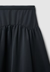 Gonna nera in tessuto con vita arricciata e materiale liscio e testurizzato. Caratterizzata da una chiusura a zip sul retro. Design semplice senza fantasie.