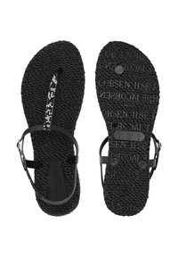 Zwarte gevlochten sandalen met dunne bandjes en een klein bloemenpatroon op het voorste bandje, met zowel boven- als onderaanzicht.