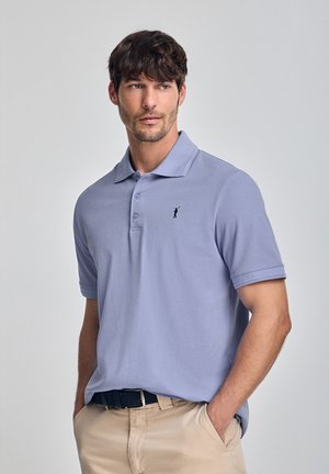 Light purple polo shirt made of cotton, featuring a three-button placket and a small black logo on the chest. Worn with khaki pants.