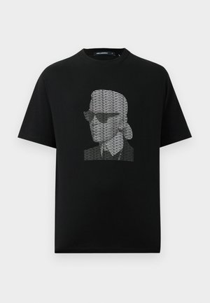 Melna kokvilnas T-kreklā ar grafisku druku, kurā attēlota stilizēta seja ar saulesbrillēm, izveidota no atkārtotu tekstu baltā krāsā. Apaļa apkakle, īsas piedurknes.